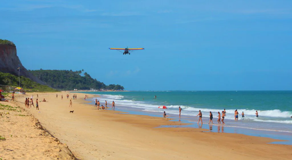 Pessoas na água e na areia da Praia de Taípe em Arraial d’Ajuda na Bahia