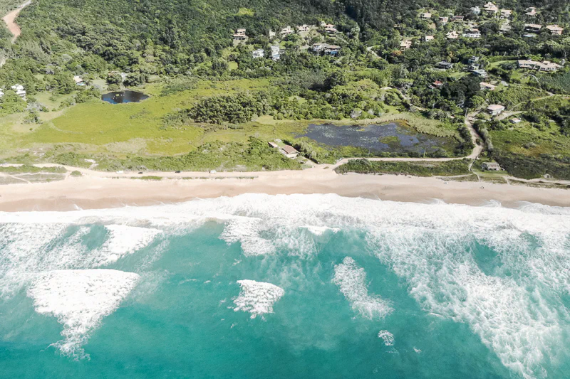 Praia da Silveira cercada por morros verdes e natureza preservada em Garopaba